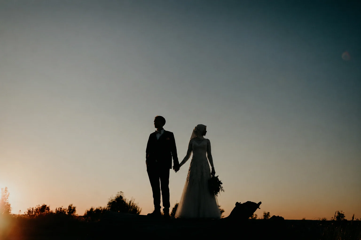 A Muslim bride and groom silhouetted against a sunset sky — Islamic marriage